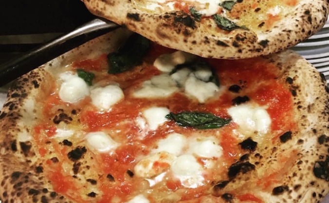Mike D'Ambra eating a Margherita at Rudy's Pizza