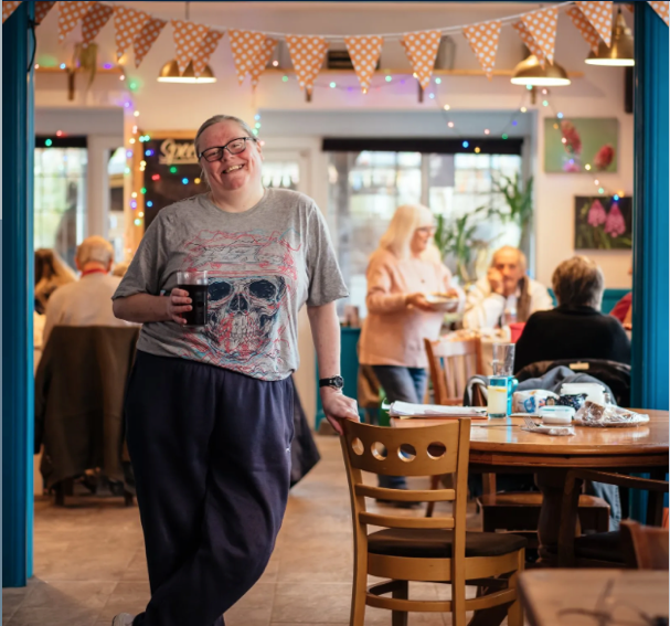 A person standing in a restaurant Description automatically generated